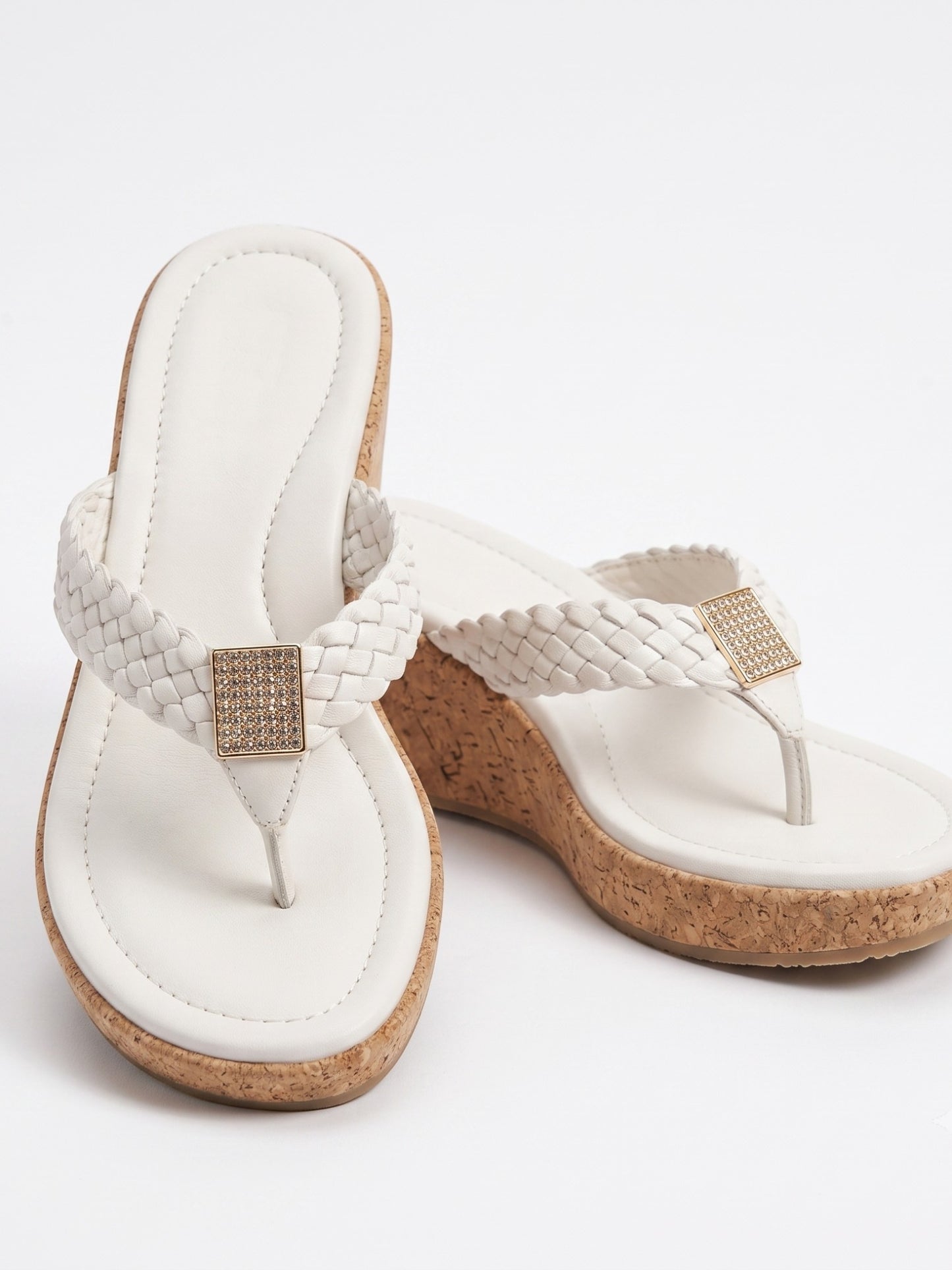 Runway Stores white braided strap thong wedge sandals with a cork heel and a shimmering square embellishment.
