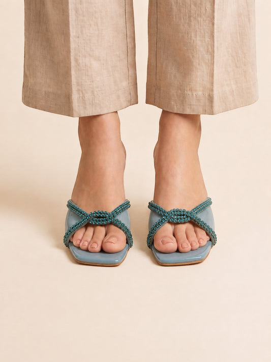 Runway Stores Diana blue synthetic block heels with a T-shaped open toe design worn with beige linen trousers.